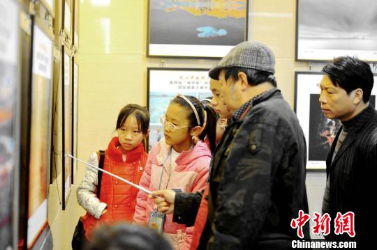 圖為獲獎作品展覽,攝影師教授小朋友攝影技巧。 圖為獲獎作品展覽,攝影師教授小朋友攝影技巧。