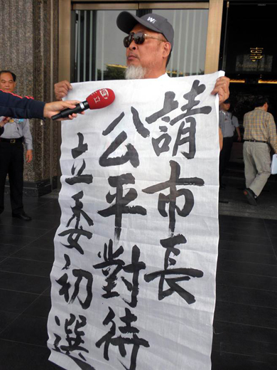 劉明松到市議會(huì)舉白布陳情 劉明松到市議會(huì)舉白布陳情