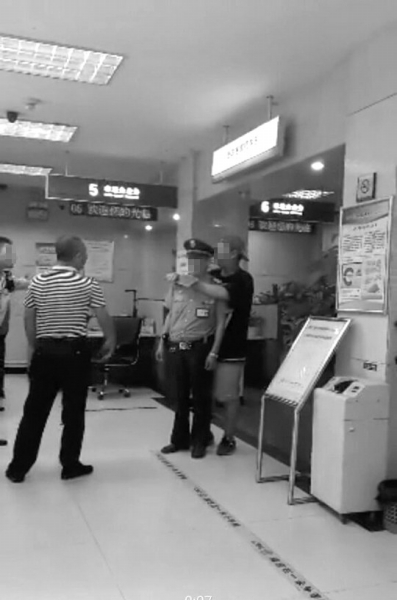 男子正持刀挾持銀行保安。網絡圖片