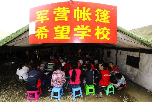 5月23日,災(zāi)區(qū)的孩子在軍營帳篷希望學(xué)校內(nèi)上課。 新華社記者 任勇 攝