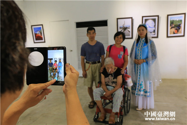 當(dāng)?shù)孛癖娕c穿著民族服飾的姑娘合影留念。(中國(guó)臺(tái)灣網(wǎng)記者 李岳 攝) 當(dāng)?shù)孛癖娕c穿著民族服飾的姑娘合影留念。(中國(guó)臺(tái)灣網(wǎng)記者 李岳 攝)