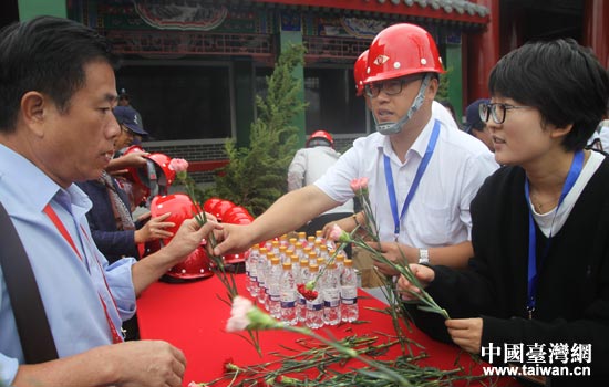 工作人員向嘉賓發(fā)放祭拜鮮花。 工作人員向嘉賓發(fā)放祭拜鮮花。
