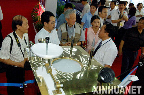 10月13日,幾名前來參觀的專業(yè)人員在“嫦娥一號”人造月球衛(wèi)星模型前交談。