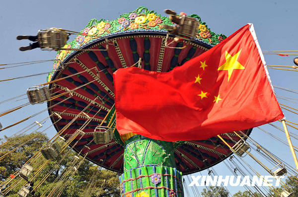 10月2日,游客在山西太原市迎澤公園里乘坐旋轉(zhuǎn)飛車。